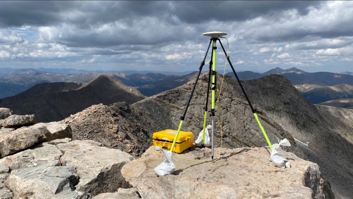 A GNSS antenna set over a survey mark on Mount Blue Sky, Colorado: the reference frames this tool converts between begin with observations like this.